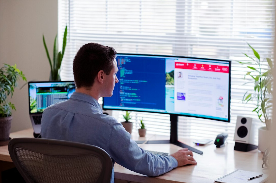 young man coding at desk